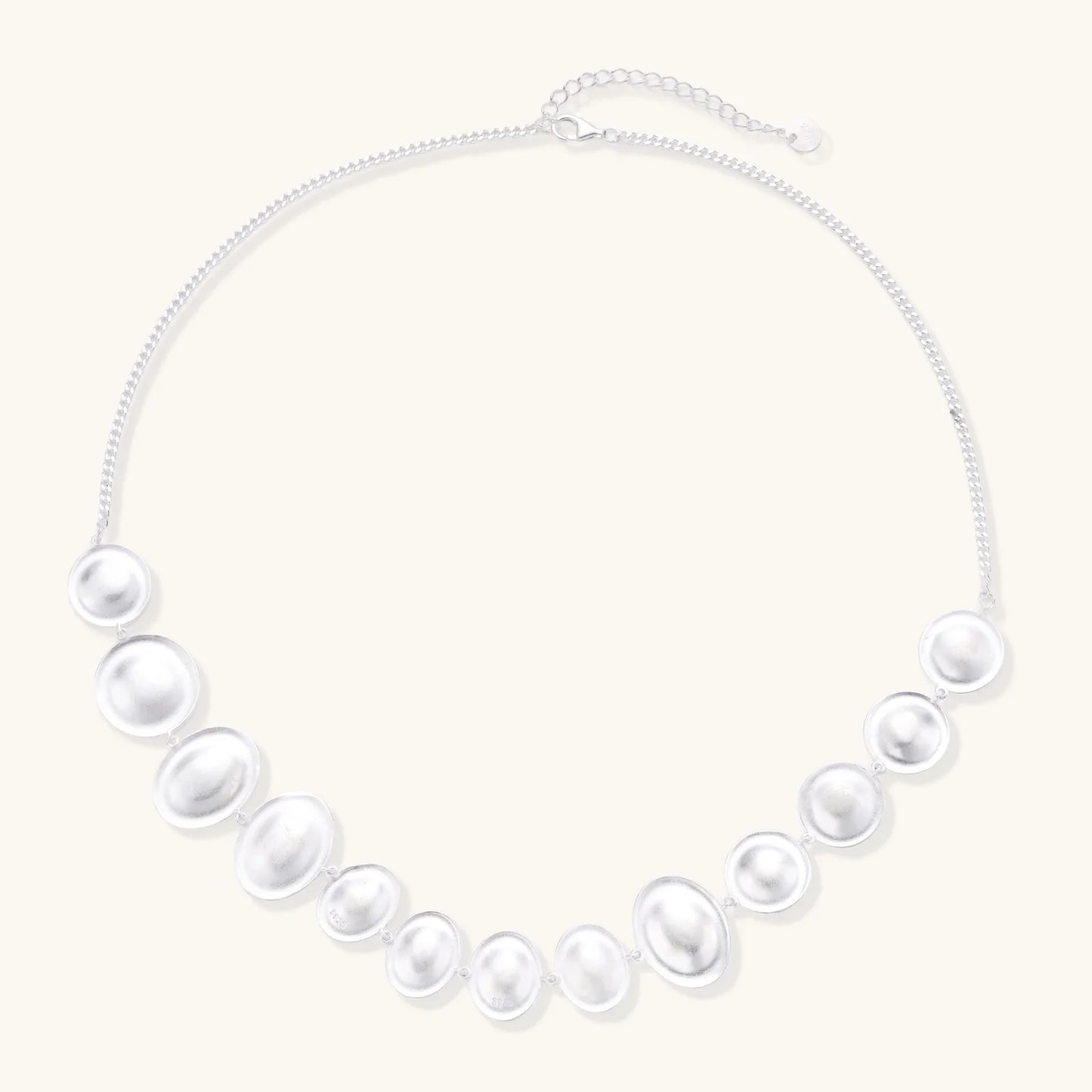 Flat lay of the Lunar Pearl Arc Necklace - Sterling Silver by Astral Signature, emphasizing its intricate details and luxurious finish. This limited edition necklace embodies Astral Design sophistication and is a perfect gift for her.