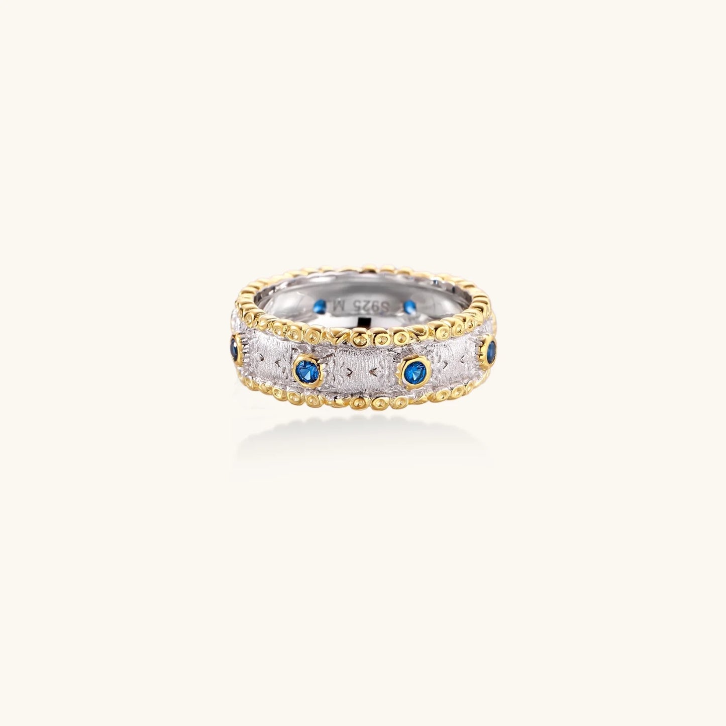 An elegant display of the Azure Dreams Band Ring by Astral Signature in a close-up shot, highlighting the combination of 24K gold vermeil and cubic zirconia, ideal for gifting her or him. This limited edition piece stands out beautifully.