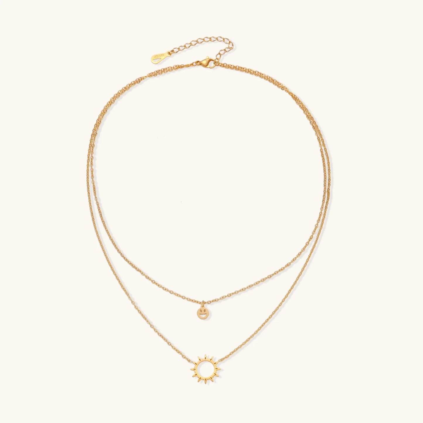 The Sunshine Smiley Layered Necklace from Astral Signature displayed against a minimalist backdrop, emphasizing its playful smiley and sun pendants. Designed for everyday wear, this limited edition piece is an ideal gift for her, capturing the essence of Astral Design.