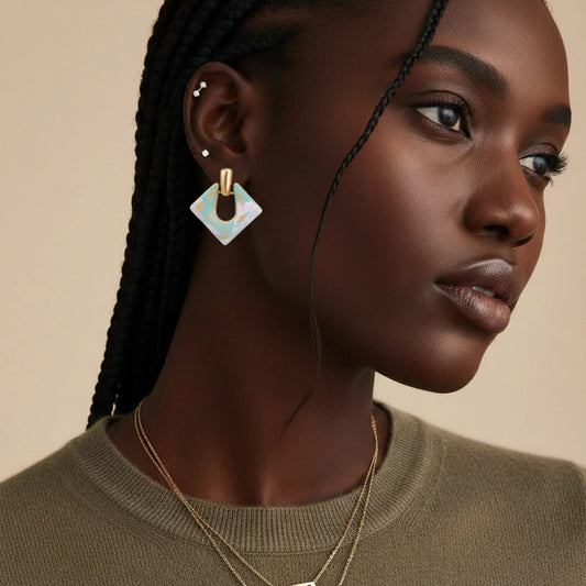 Close-up of the Dream Marble Diamond Drops by Astral Signature, highlighting the exquisite geometric drop shape and luxurious 18K gold plating. Ideal for adding a touch of sophistication to any outfit, this limited edition piece strikes the perfect balance for everyday wear or as a gift for her. Crafted by Astral Signature with a focus on Astral Design.