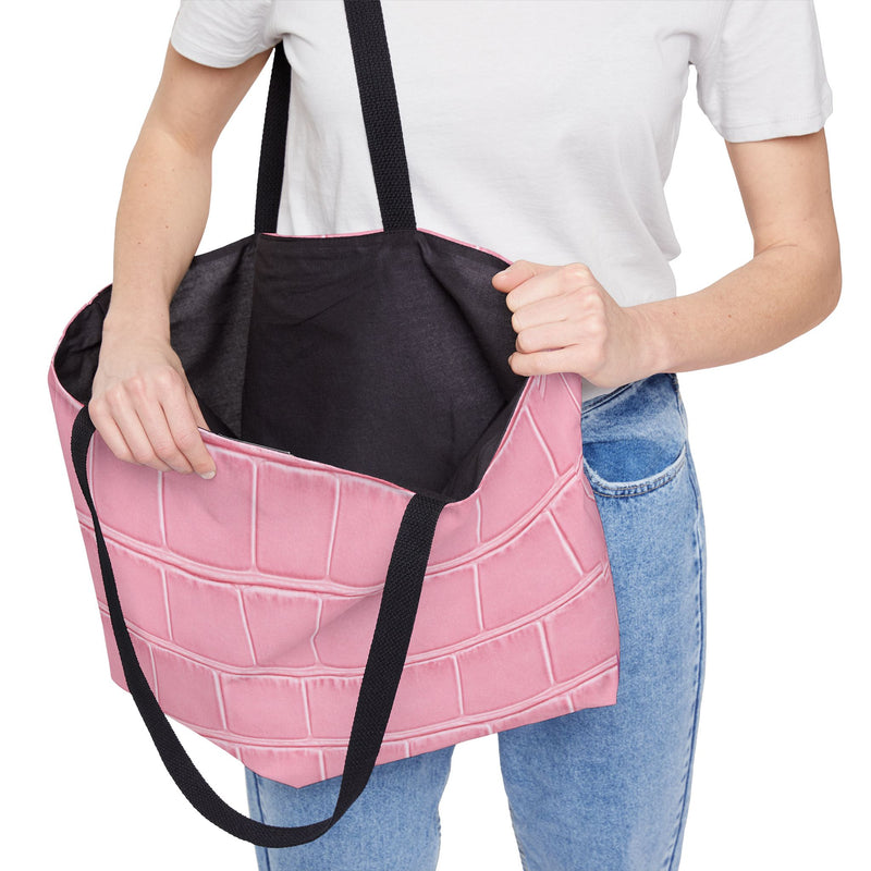 A person holding the Weekender Tote Bag - Structured Croc-Embossed in Light Pink by Astral Signature, demonstrating its practical interior that makes it a versatile carry all bag for work, weekends, and beach outings.