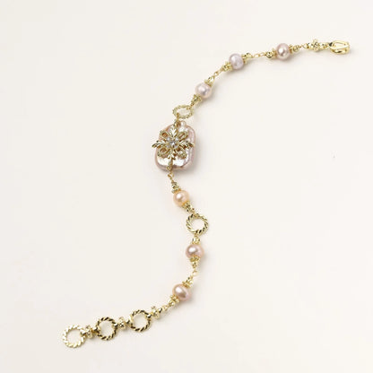 Gold-plated bracelet with pink baroque pearl centerpiece, floral connector, and freshwater pearls