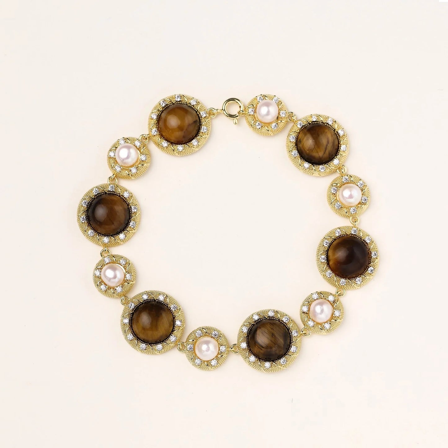 Gold-plated link bracelet with alternating brown tiger's eye stones and white freshwater pearls in ornate bezels.