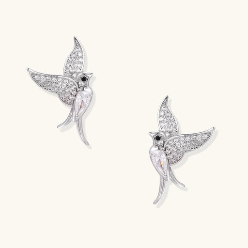 Celestial Hummingbird Earrings featured in a close-up view, showcasing their sparkling zirconia wings and elegant design. This exquisite pair, crafted by Astral Signature, is made of eco-brass with white gold plating, ideal as a gift for her and made with S925 sterling silver posts for comfort.