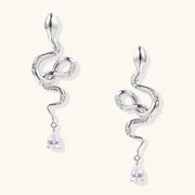 Serpentine Crystal Drops by Astral Signature featuring elegant drops and earrings crafted from Eco-Brass. These stunning White Gold Plated Eco-Brass earrings showcase a design embellished with zirconia and Sterling Silver (S925) posts.
