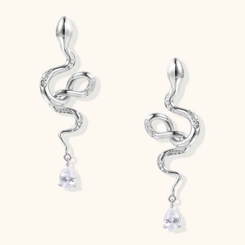 Serpentine Crystal Drops by Astral Signature featuring elegant drops and earrings crafted from Eco-Brass. These stunning White Gold Plated Eco-Brass earrings showcase a design embellished with zirconia and Sterling Silver (S925) posts.