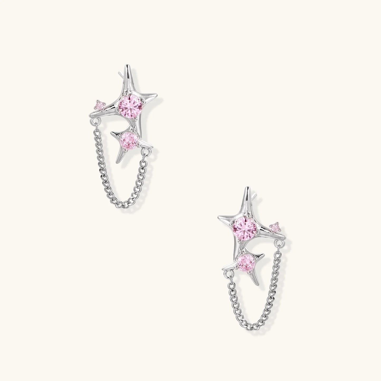 Pair of silver star-shaped ear climbers with pink zirconia stones connected by delicate chains