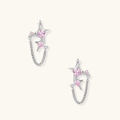 Pair of silver star-shaped ear climbers with pink zirconia stones connected by delicate chains