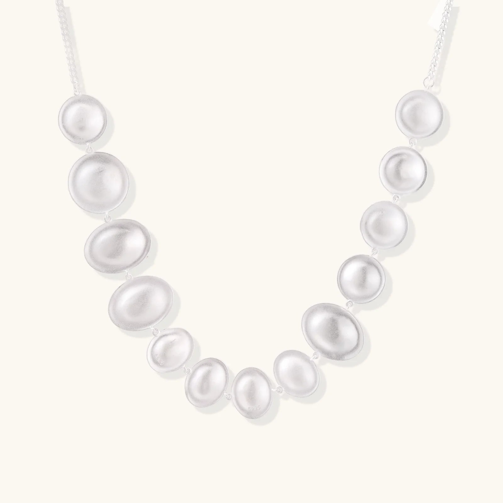 The stunning Lunar Pearl Arc Necklace - Sterling Silver by Astral Signature displayed against a neutral background, highlighting its impressive pearlescent design. An elegant addition to any jewelry collection, this limited edition piece is a great gift for her.