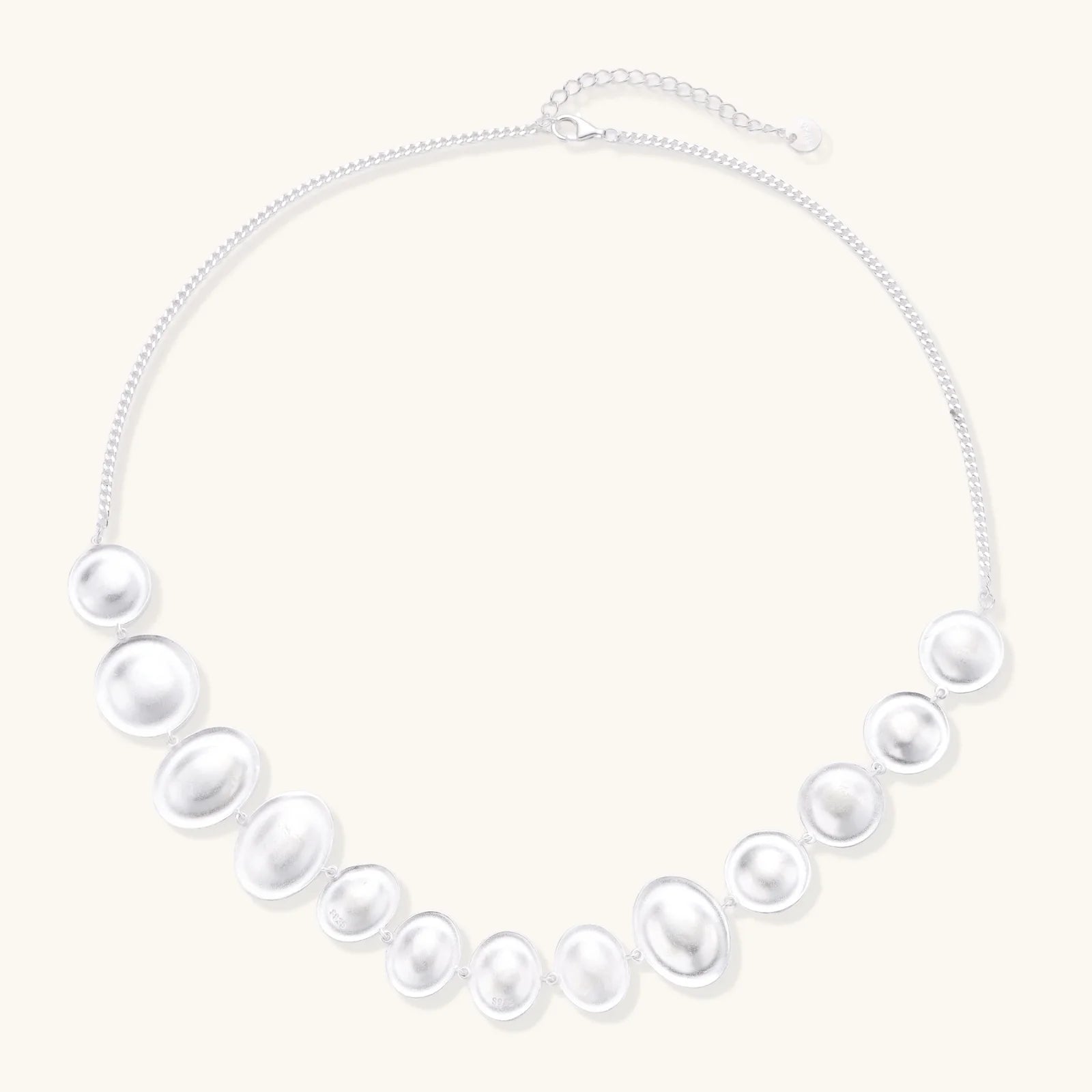 Flat lay of the Lunar Pearl Arc Necklace - Sterling Silver by Astral Signature, emphasizing its intricate details and luxurious finish. This limited edition necklace embodies Astral Design sophistication and is a perfect gift for her.