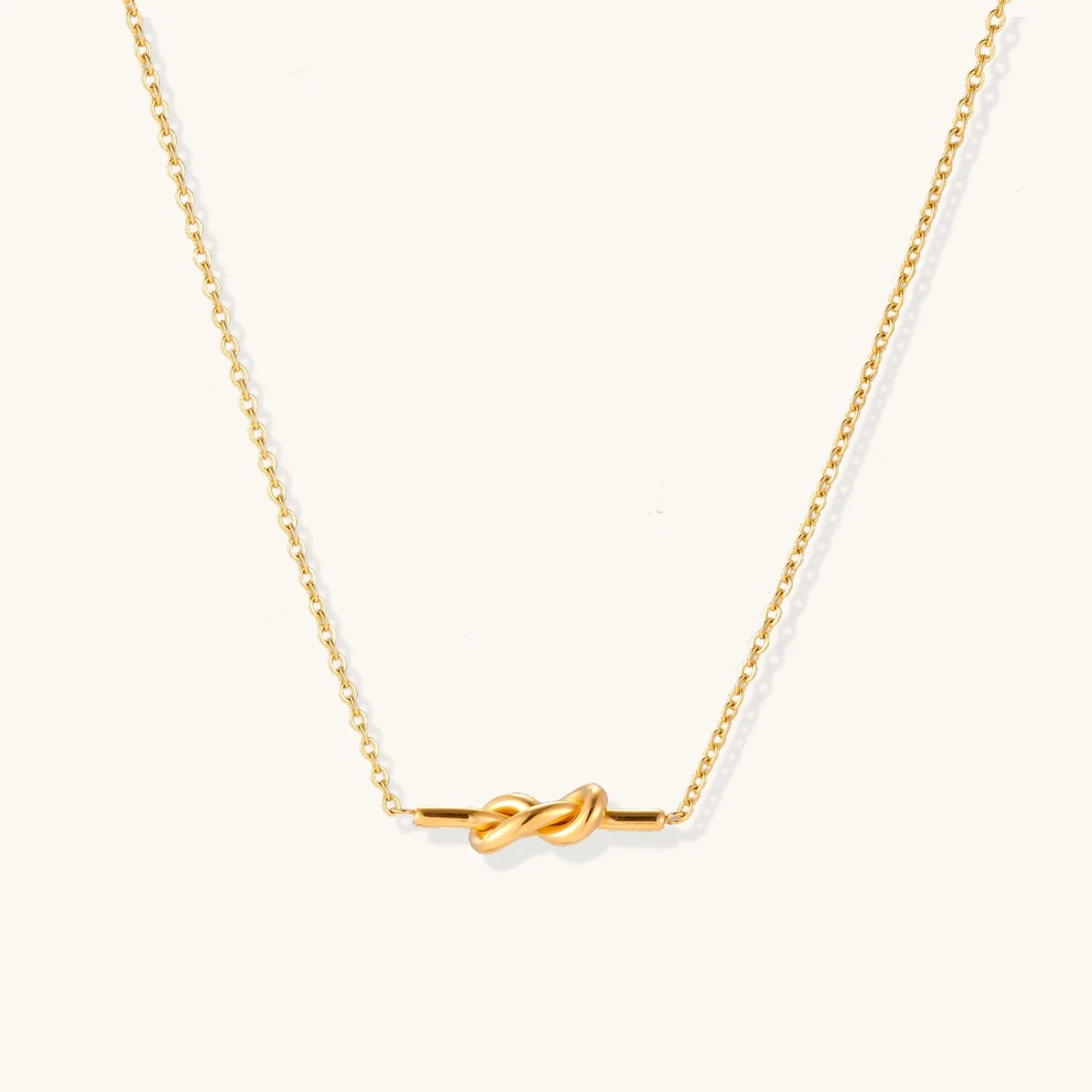 An isolated image of the 18K gold-plated Unity Knot Necklace by Astral Signature™, focusing on the intricate knot design and shiny finish. This photo emphasizes the elegance of Astral Design and makes for a perfect Gift for Her within the Limited Edition collection.
