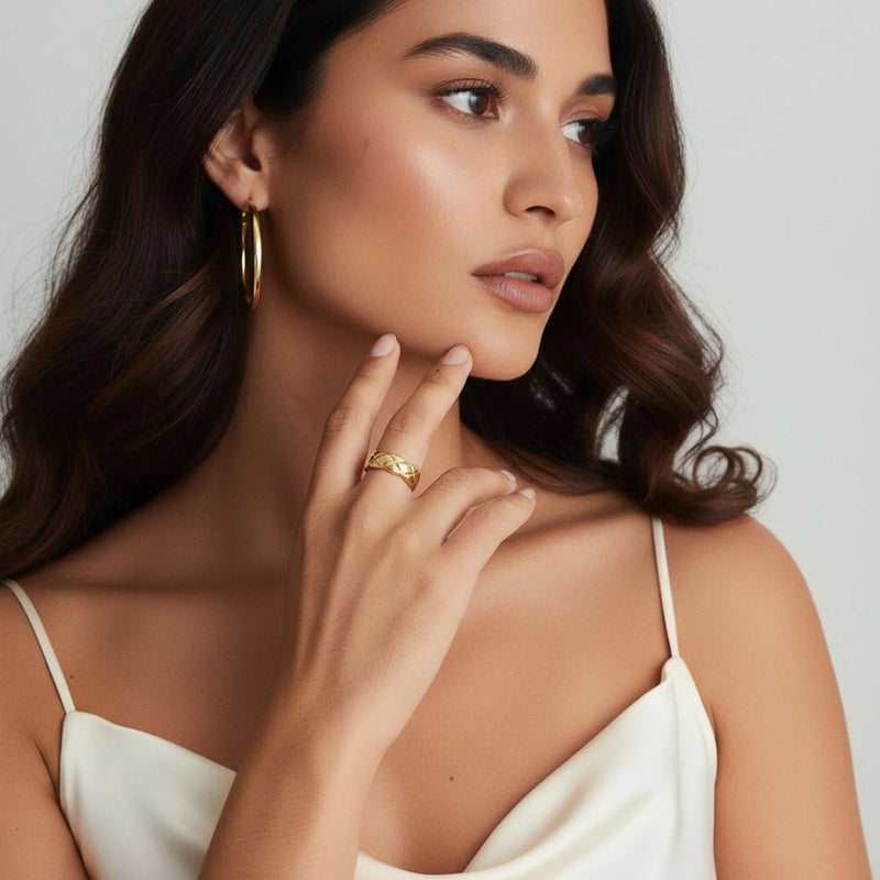 A woman wearing the Twisted Luxe Band by Astral Signature, showcasing its unique braided design in 18K gold-plated stainless steel. This striking piece of jewelry embodies both style and durability, making it perfect for everyday wear or as a thoughtful gift for her. Designed for the fashion-forward individual, this limited edition band highlights the luxurious craftsmanship of Astral Design.