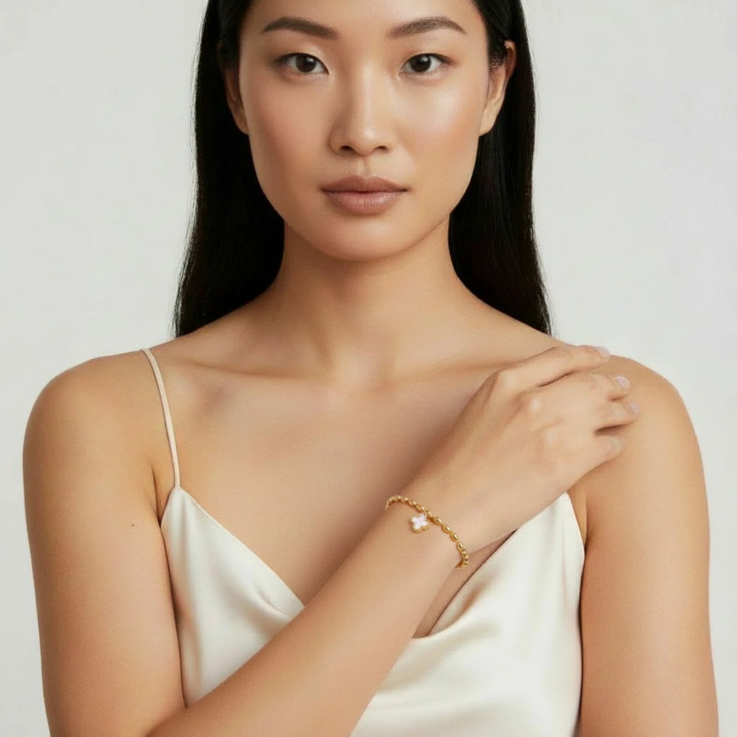 A model showcasing the Lucky Clover Beaded Bracelet by Astral Signature™ with a quatrefoil charm and luminous mother of pearl. Ideal for everyday wear, this elegant piece makes a great gift for her. Part of a limited edition collection from Astral Design.