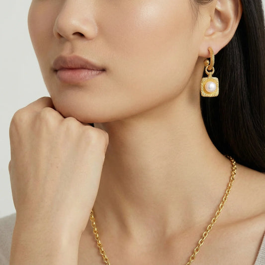 Close-up view of a model wearing Golden Pearl Drop Hoops by Astral Signature, featuring a radiant freshwater pearl in a hammered gold vermeil setting. Perfect for everyday wear, this limited edition piece makes an ideal gift for her. Astral Design offers a blend of elegance and contemporary style.