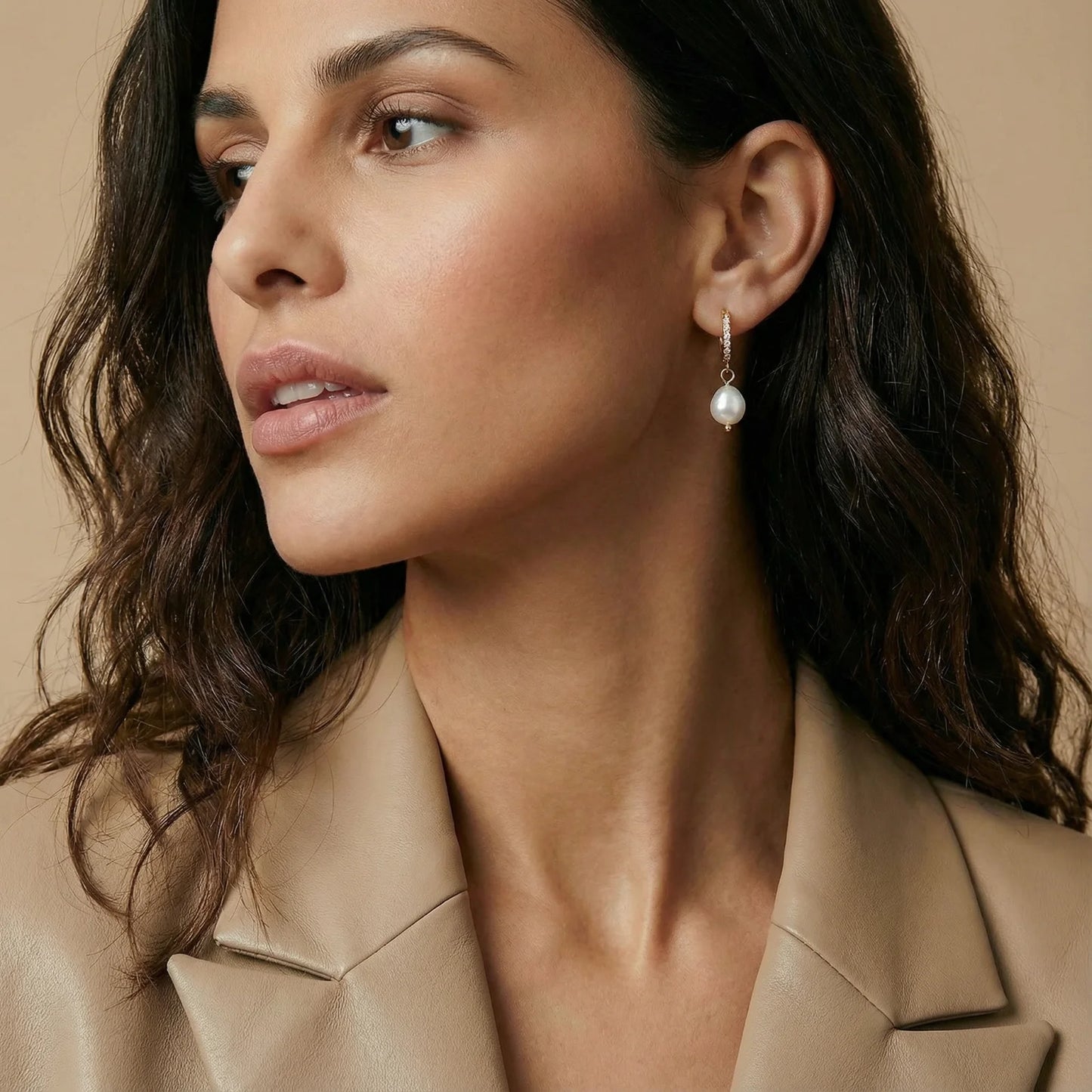 A side profile of a woman wearing Pearl Drop Hoops - Freshwater Pearl - 18K Gold Plated Stainless Steel by Astral Signature, highlighting its chic style. Ideal for everyday wear, this piece serves as a lovely gift for her, embodying the essence of limited edition Astral Design.