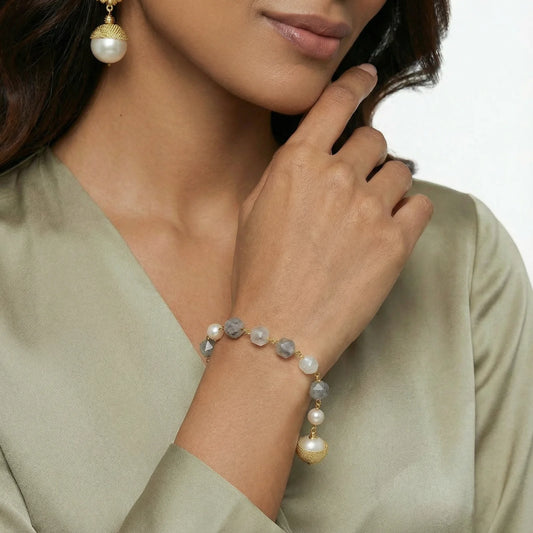 A model showcasing the Baroque Pearl Crystal Bracelet from Astral Signature, featuring lustrous freshwater pearls and cloudy quartz. This elegant piece, crafted with 14K Gold Plated Eco-Brass, is perfect for everyday wear and makes a great gift for her. Explore the limited edition Astral Design collection.