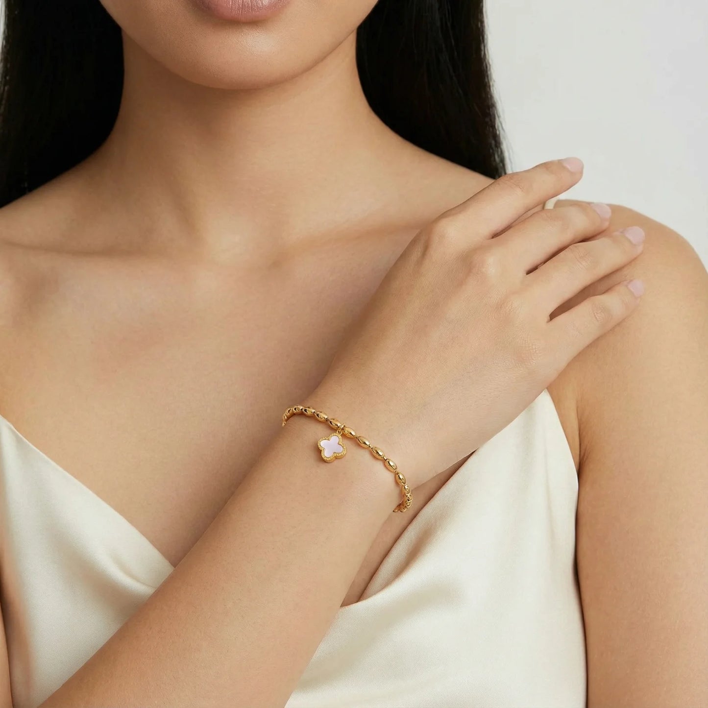 Close-up of the Lucky Clover Beaded Bracelet by Astral Signature™, featuring a lovely pink quatrefoil charm. This charm bracelet is perfect for everyday wear and an exquisite gift for her. Experience the beauty of this limited edition design from Astral Signature.