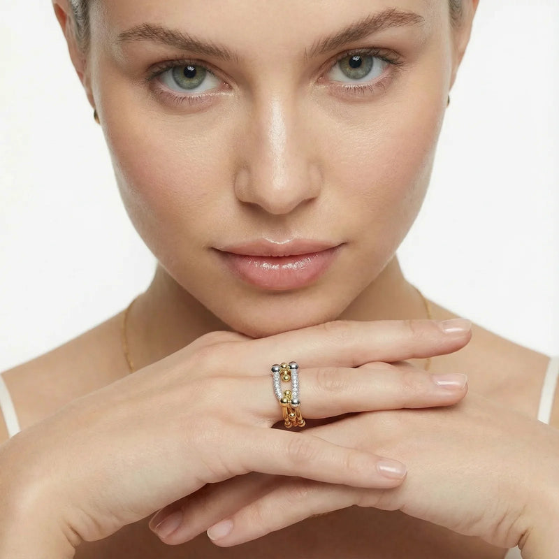 A close-up of a model wearing the Chain Link Power Ring by Astral Signature, showcasing sparkling cubic zirconia and 18K gold-plated eco-brass. This elegant piece embodies contemporary style, making it a perfect choice for everyday wear or a thoughtful gift for her. Explore this limited edition design from Astral Design.