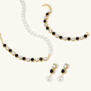 Elegant display of the Astral Signature™ Noir Luxe black and gold jewelry set, highlighting the necklace and bracelet with a focus on the zirconia stones.