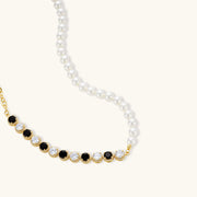 Close-up of the necklace from the Astral Signature™ Noir Luxe black and gold jewelry set, featuring alternating black and clear zirconia accents.