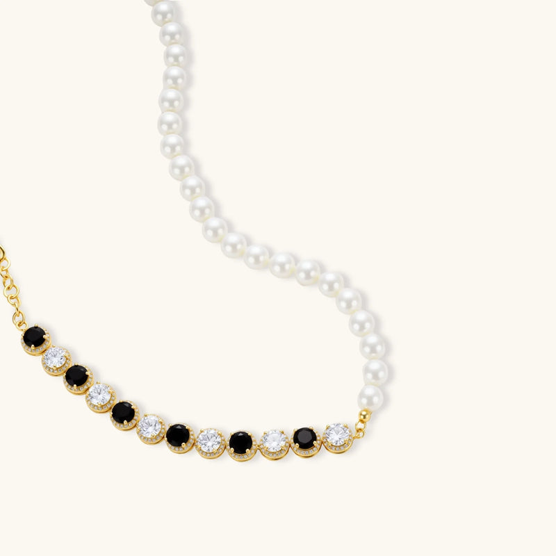 Close-up of the necklace from the Astral Signature™ Noir Luxe black and gold jewelry set, featuring alternating black and clear zirconia accents.