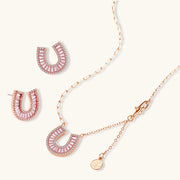 Gold horseshoe jewelry set displayed together, including necklace and earrings, created by Astral Signature with a modern twist.