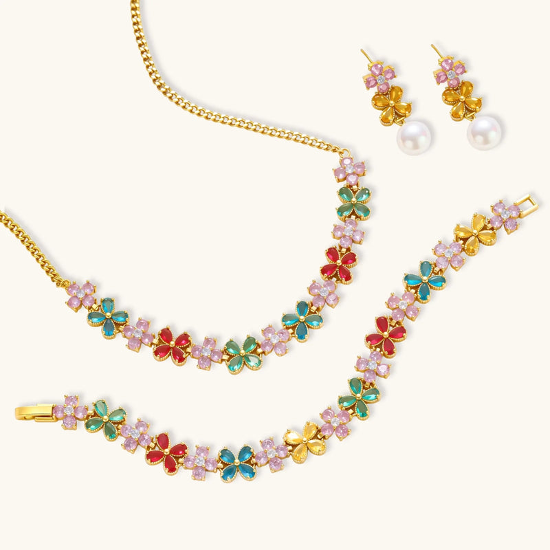 Flat lay of the Garden Bloom Jewelry Set including a necklace, bracelet, and earrings, all adorned with floral motifs and vibrant colors by Astral Signature.