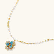 Close-up of the floral pendant necklace from the Blooming Elegance — Blue and Pearl Jewelry Set in 14K Gold by Astral Signature™, featuring pearl accents.