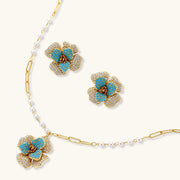 Blooming Elegance — Blue and Pearl Jewelry Set in 14K Gold by Astral Signature™, including detailed view of the floral necklace and earrings with blue zirconia.