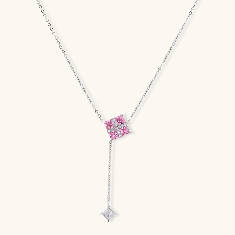 Detailed view of the Pink Prism Cross Set from Astral Signature, featuring a geometric cross pendant with pink zirconia stones.