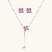 Pink Prism Cross Set jewelry by Astral Signature featuring a cross pendant necklace and matching earrings with pink zirconia stones.