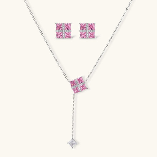 Pink Prism Cross Set jewelry by Astral Signature featuring a cross pendant necklace and matching earrings with pink zirconia stones.