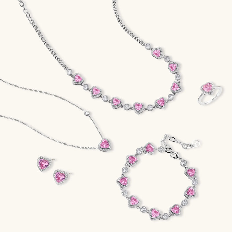 A close-up view of the delicate Romance Heart Set jewelry pieces including a necklace and bracelet adorned with pink zirconia hearts, showcasing the craftsmanship of Astral Signature™.