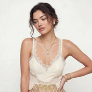 Model wearing the Emerald Cut Halo Set, including a pendant necklace and stud earrings by Astral Signature. The jewelry complements her elegant attire, adding a touch of sophistication.