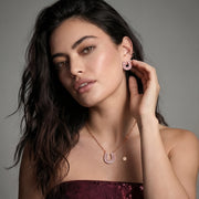 Model showcasing the gold horseshoe jewelry set including earrings and a necklace by Astral Signature, highlighting modern and elegant design.