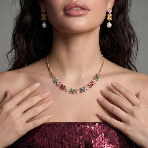 Model wearing the Garden Bloom Jewelry Set by Astral Signature, featuring a floral necklace and earrings, highlighting vibrant colors in a sophisticated style.