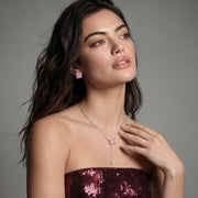 Model wearing the Pink Prism Cross Set from Astral Signature, showcasing the pink zirconia jewelry with a stylish outfit.