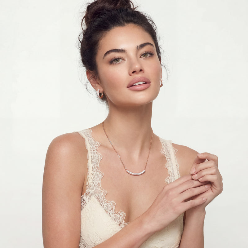 Model showcasing the Sparkling Confidence Set by Astral Signature™, wearing a rose gold plated necklace and earrings, exuding elegance and confidence.