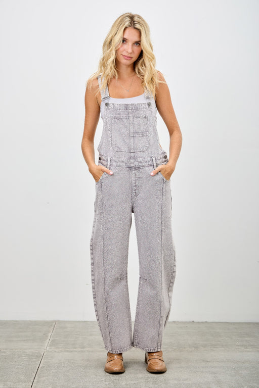 Model wearing Barrel Overalls from SAIGE DENIM, showcasing a modern utility design in grey. This relaxed-fitting overall is perfect for women's casual apparel, ideal for jumpsuits & rompers, featuring pockets and a stylish silhouette.