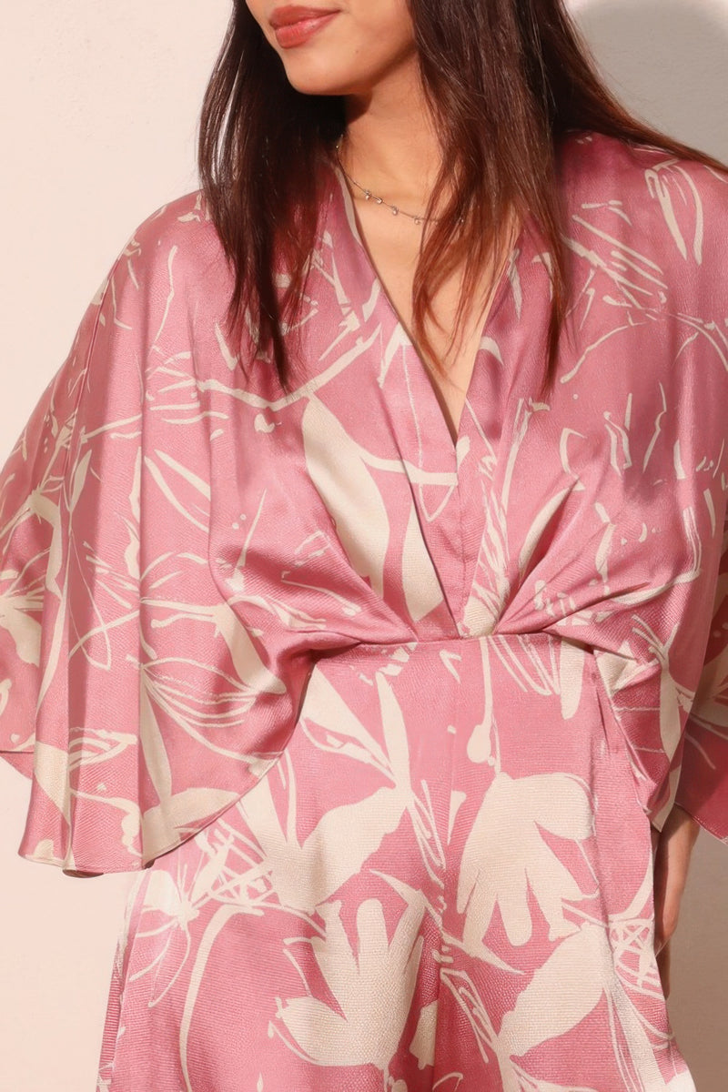 Close-up of the bodice of the Astral Women's Jumpsuit - Dreaming Lily Satin Cape by TYCHE, highlighting the luxurious satin fabric and intricate floral print, perfect for formal and evening events. This Women's Jumpsuit is a striking addition to any woman's wardrobe. APPAREL, CCPRODUCTS, JUMPSUITS & ROMPERS, NEW ARRIVALS, Pink, Women's, Women's Clothing, Women's Style.