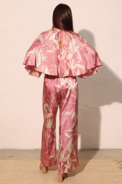 Back view of the Astral Women's Jumpsuit - Dreaming Lily Satin Cape by TYCHE, presenting a stunning cape silhouette that enhances movement and style, perfect for evening wear. This Women's Jumpsuit is an essential piece for refined women's clothing collections. APPAREL, CCPRODUCTS, JUMPSUITS & ROMPERS, NEW ARRIVALS, Pink, Women's, Women's Clothing, Women's Style.