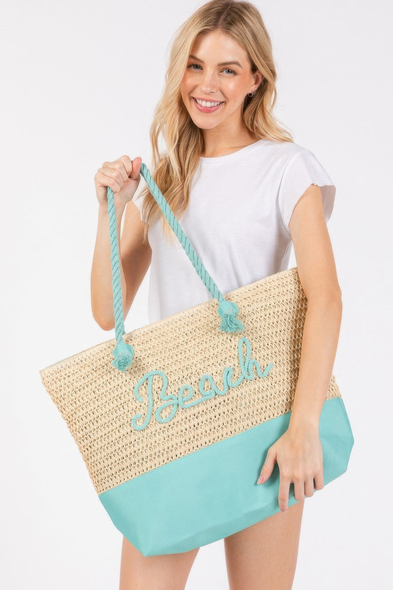 A cheerful model holding the Rope Handle Beach Tote by HD ACCESSORIES, designed with a refreshing Turquoise bottom and crochet top featuring 'Beach' details. This versatile Tote Bag is designed for your summer adventures, aligning with trending NEW ARRIVALS like the Hot Pink and Navy versions.