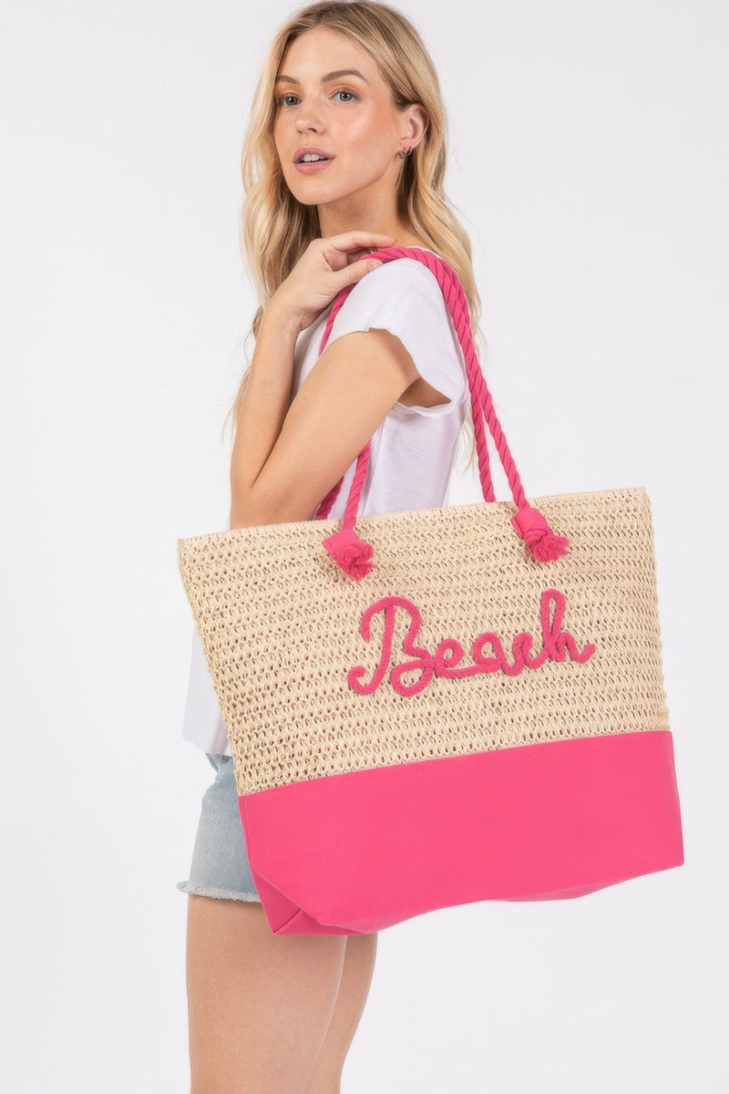 The Rope Handle Beach Tote from HD ACCESSORIES in a vibrant hot pink shade, held by a model, demonstrates its perfect fit for summer outings. This Beach Tote Bag balances style and spaciousness, featuring beach-inspired lettering while being available in various trendy colors including Coral and Turquoise.