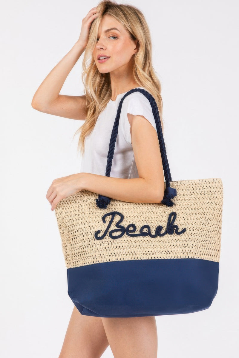 A model poses with the Rope Handle Beach Tote in Navy, designed by HD ACCESSORIES, showcasing its sturdy crochet style and spaciousness for beach essentials. This trendy Beach Tote Bag is part of the latest NEW ARRIVALS, also available in stylish colors like Coral and Hot Pink.