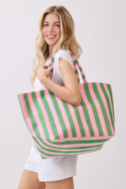 A woman showcasing a green and pink striped Beach Tote Bag - Striped Tote Bags from HD ACCESSORIES, demonstrating the plush terrycloth material. This stylish tote is ideal for casual outings and available in colors like Orange and Yellow, now a part of ACCESSORIES.