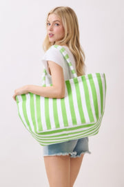 A woman facing away, holding a green striped Beach Tote Bag - Striped Tote Bags from HD ACCESSORIES. Perfect for beach trips, this tote is available in different colors like Orange and Pink green, featured in the ACCESSORIES category.