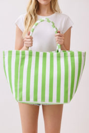 A woman holding a vibrant green striped Beach Tote Bag - Striped Tote Bags by HD ACCESSORIES, showcasing its plush terrycloth texture. Perfect for casual outings and ideal in various colors like Orange, Pink green, and Yellow. Discover this stylish accessory in the NEW ARRIVALS category.