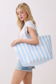 A woman modeling a blue striped Beach Tote Bag - Striped Tote Bags from HD ACCESSORIES, highlighting its stylish appearance and practical size. Perfect for casual outings, this tote comes in various colors like Green and Yellow, categorized under HIP ACCESSORIES.