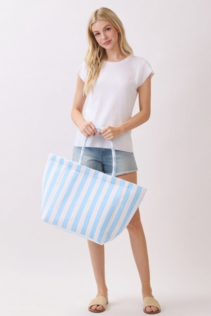 A woman posing with a pink and gray striped Beach Tote Bag - Striped Tote Bags from HD ACCESSORIES, showcasing its spacious design. Ideal for daily errands, this stylish tote is available in various colors including Orange and Green, featured in ACCESSORIES.