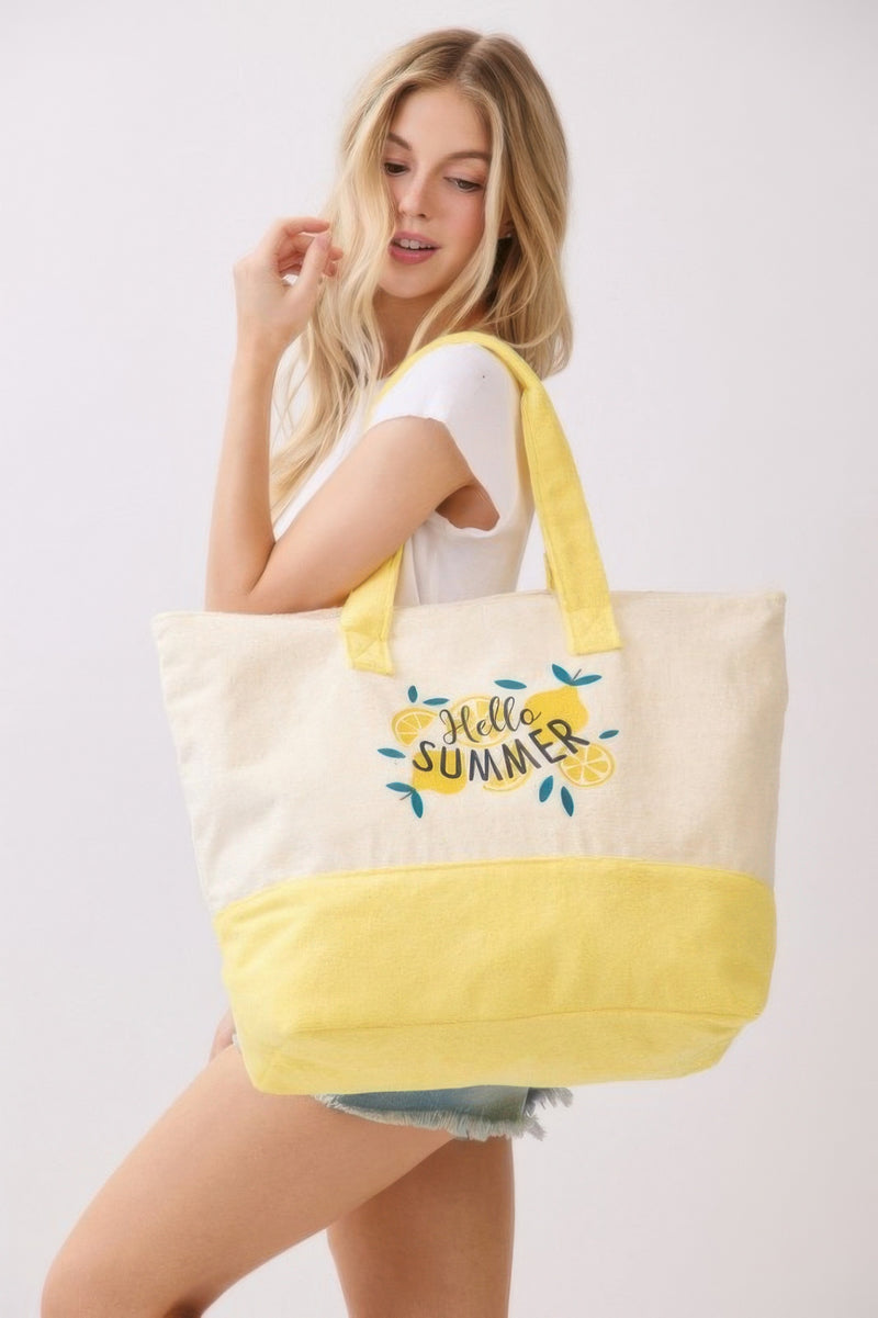 Model casually displays the Beach Tote Bag in Yellow by HD ACCESSORIES with the vibrant 'Hello Summer' graphic, ideal for outings to the beach or market. This new arrival is perfect for summer.